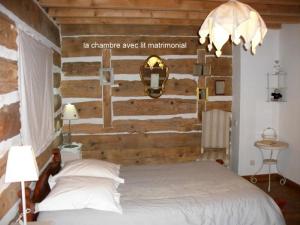 - une chambre avec un mur en bois et un lit dans l'établissement Ker Cambre, à Saint-Pierre-dels-Forcats