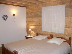 two beds in a bedroom with a wooden wall at Ker Peric in Saint-Pierre-dels-Forcats