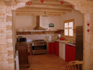 - une cuisine avec des appareils rouges et blancs dans l'établissement Ker Puigmal, à Saint-Pierre-dels-Forcats