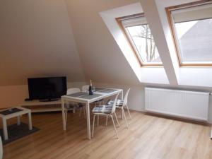 uma sala de estar com uma mesa com cadeiras e uma televisão em Apartmán Kamenice em Kamenice nad Lipou