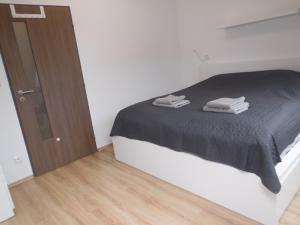 um quarto com uma cama preta e uma porta de madeira em Apartmán Kamenice em Kamenice nad Lipou