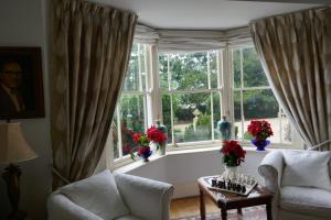 a living room with a large window with vases at Kerrington House in Axminster