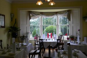 a room with tables and chairs and a large window at Kerrington House in Axminster