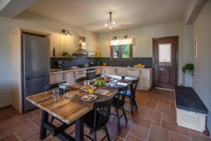 una cocina con mesa de madera y sillas. en Citrus House, en Razáta