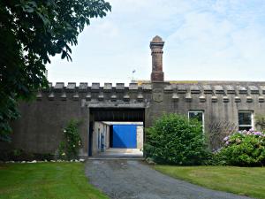 a brick building with a blue door and a chimney at Kiltariff Hall Country House in Rathfriland