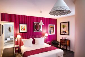ein Hotelzimmer mit einem Bett und einer roten Wand in der Unterkunft Le Clos de Villeroy in Mennecy