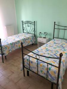 a bedroom with two beds and a night stand at Appartamento Gemma in Martinsicuro