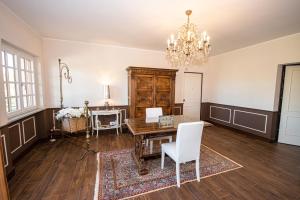 uma sala de jantar com uma mesa e cadeiras e um lustre em Home Holiday La Selva em Cassano Spinola