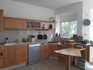 eine Küche mit Holzschränken und einem weißen Kühlschrank in der Unterkunft Oren's place - perfect for families & friend's in Kefar Weradim