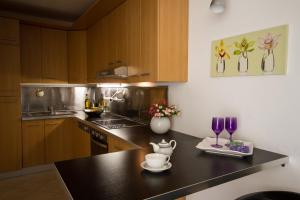 une cuisine avec des placards en bois et un comptoir noir dans l'établissement Apartments Casa Emonia, à Novigrad