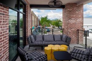 un patio avec des tables et des chaises jaunes dans un bâtiment dans l'établissement Hyatt Place Mount Pleasant Towne Centre, à Charleston