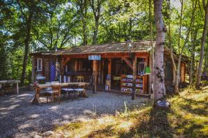 eine kleine Hütte im Wald mit einem Tisch und Stühlen in der Unterkunft Chalets & Camping Villa Mayari in Escosse