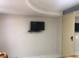 Habitación con TV de pantalla plana en una pared blanca. en Atlântico Flat - Apto 109 en Natal