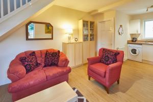 ein Wohnzimmer mit einem roten Sofa und einem Stuhl in der Unterkunft Host & Stay - The Limes in Harrogate