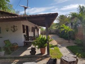 a patio of a house with a wooden pergola at Pousada da Mamae in Barra Grande
