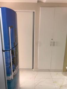 Cette chambre comprend un réfrigérateur bleu et des armoires blanches. dans l'établissement Atlântico Flat - Apto 109, à Natal