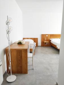 A est b&b Otranto في أوترانتو: غرفة نوم بسريرين وطاولة عليها ورد
