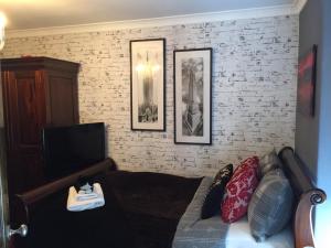 een woonkamer met een bank en een tv bij The Clacks Rustic Abode in Tillicoultry