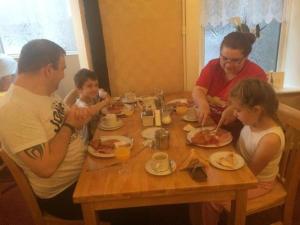 黑潭的住宿－金斯克洛斯酒店，一群坐在餐桌上吃食物的人