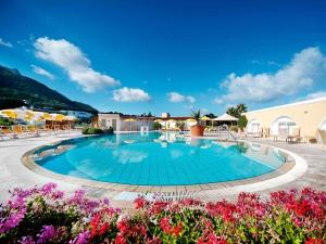 a large swimming pool in a resort with flowers at Hotel Parco Delle Agavi in Forio d'Ischia