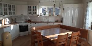 a kitchen with a wooden table and white cabinets at B&B Friendsroom 2 persons in Mellerud