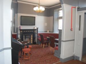 een woonkamer met een open haard en een tafel en stoelen bij The Kings Head in Warrington
