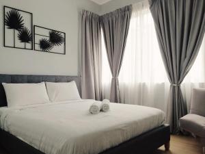 a bedroom with a bed with two towels on it at 3 Bedrooms FULLY AIRCOND,near MSU , Shah Alam stadium in Shah Alam