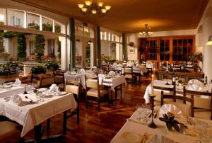 un comedor con mesas y sillas blancas en Hotel Beausite en Interlaken