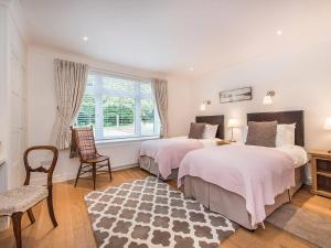 1 dormitorio con 2 camas, silla y ventana en Knole B&B, en Sevenoaks