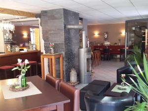 a restaurant with a table and chairs and a fireplace at Weincafé Korkenzieher in Briedel