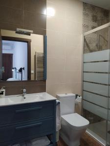 ein Badezimmer mit einem Waschbecken, einem WC und einem Spiegel in der Unterkunft Casa Pedro Páez in Belmonte