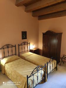 a bedroom with two beds and a dresser at Sorella Luna in Siracusa