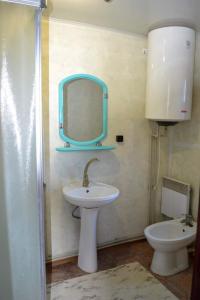 a bathroom with a sink and a mirror and a toilet at ЮрДар in Iltsi