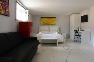 a living room with a bed and a couch at Dimore Pietrapenta Apartments, Suites & Rooms - Via Lucana 223, Via Piave 23, Via Chiancalata 16, Vico Fornaci 9 in Matera