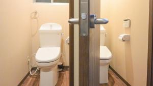a bathroom with two toilets in a bathroom stall at Kyougetsu-an in Kyoto