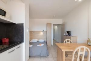 une petite chambre avec une table et une petite cuisine dans l'établissement Appart'Hôtel Agathea, au Cap d'Agde