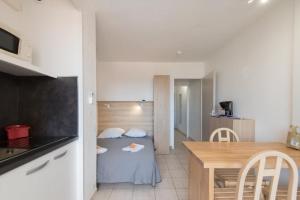 a small room with a table and a small kitchen at Résidence Agathéa - Esprit Hôtel - Centre Port - Cap d'Agde in Cap d'Agde