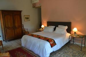 ロルグにあるLa Bastide des Enquèsesのベッドルーム1室(大型ベッド1台、白いシーツ、枕付)