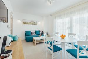 sala de estar con mesa y sofá azul en Apartments Villa Swissmonte, en Herceg-Novi
