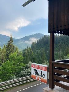 ein Schild an der Seite eines Gebäudes mit Bergblick in der Unterkunft Pensiunea Turistică Tihuța in Piatra Fântânele