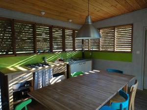 eine Küche mit einem Holztisch und einer Holzdecke in der Unterkunft La Carri'air in Pont-Aven