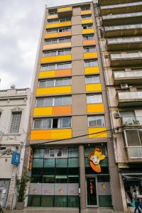 a tall building with a yellow sign on the side of it at Roberta Rosa De Fontana Suites in Rosario