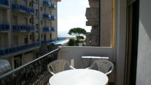 a white table and chairs on a balcony at Residence El Palmar DA COLLA in Lido di Jesolo