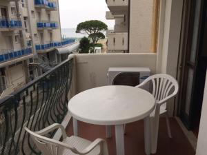a white table and two chairs on a balcony at Residence El Palmar DA COLLA in Lido di Jesolo