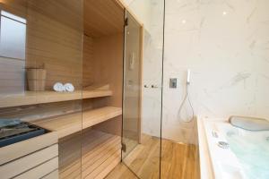 La salle de bains est pourvue d'une douche en verre et d'un lavabo. dans l'établissement La Demeure des Sacres - Cathédrale, à Reims