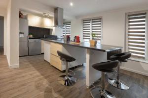 una cocina con una encimera grande con taburetes. en La Dimière - Appartements de standing en hyper-centre - Louviers, en Louviers