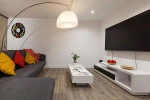 a living room with a couch and a flat screen tv at La Dimière - Appartements de standing en hyper-centre - Louviers in Louviers