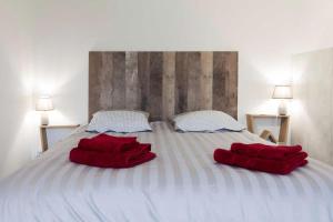 Una cama con dos almohadas rojas. en La Dimière - Appartements de standing en hyper-centre - Louviers, en Louviers
