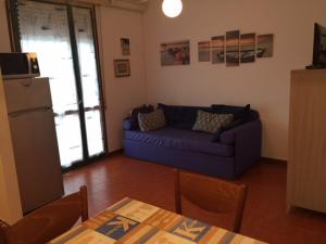 a living room with a blue couch and a table at Residence El Palmar DA COLLA in Lido di Jesolo