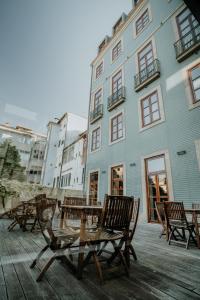 a group of chairs and a table in front of a building at Eurostars das Artes in Porto